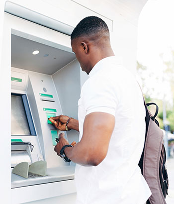Man at an ATM withdrawing money